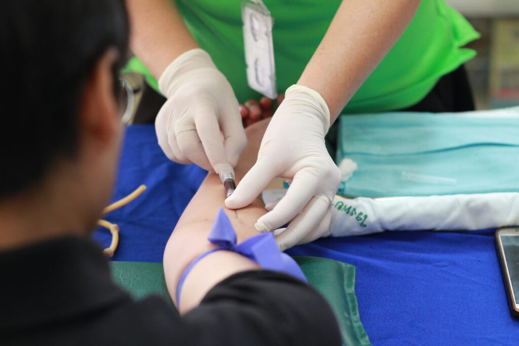 pexels-photo-1350560-1350560 A healthcare professional administering an injection to a patient's arm during a medical procedure.